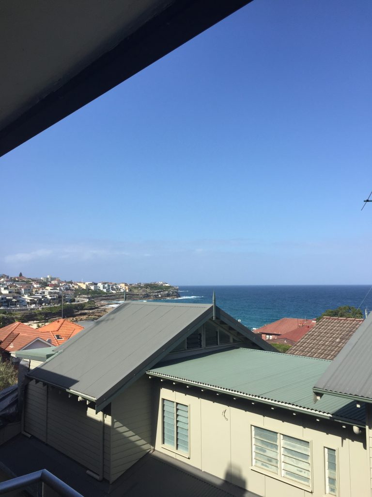 slightly obstructed view of the ocean and Bronte Beach from the balcony of my Airbnb rental