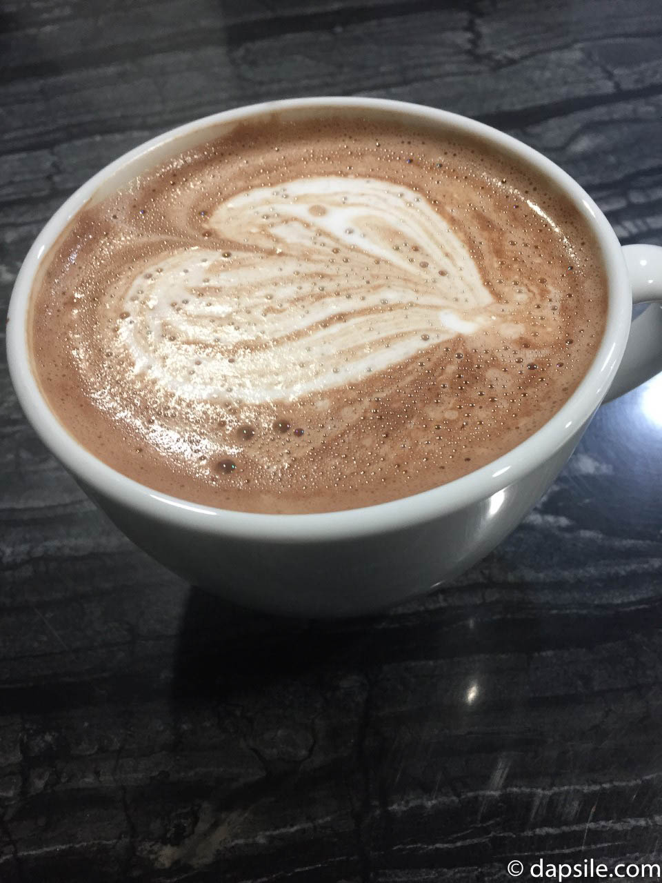 Waves Hot Chocolate in a mug with a heart pattern in the milk