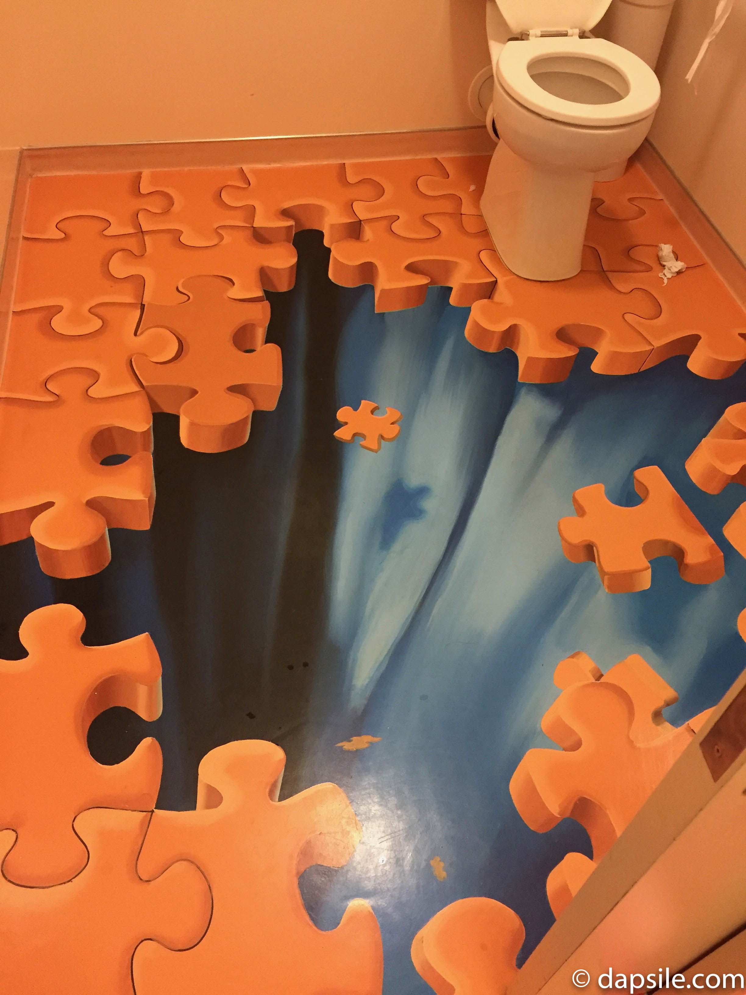 Puzzling World Puzzle Bathroom where the floor is puzzle pieces falling down into a hole
